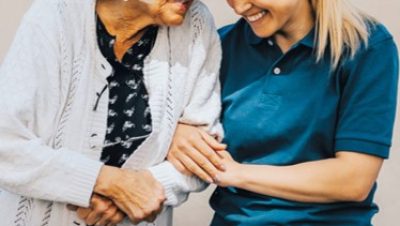 Kaksi naista pitävät toisistaan kiinni ja hymyilevät. Teksti: Etsivä vanhustyö auttaa katveeseen jääneitä ikäihmisiä. Marraskuu 2023. Logo valli.fi.