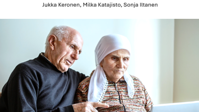 Kaksi iäkästä henkilöä katsoo tietokonetta. Tietokonetta käyttävällä naisella on valkoinen päähuivi. Mies osoittaa ruutua.